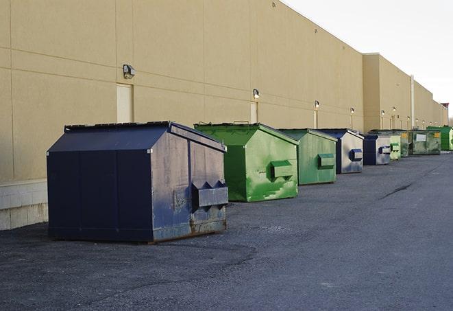 tilted front-load dumpsters being emptied by waste management workers in Charlestown, IN